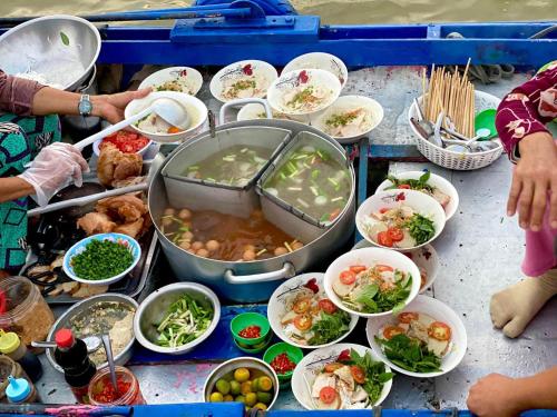 芹苴Hometravel Mekong Can Tho的一张桌子上放着许多碗食物
