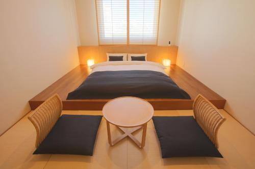 石垣岛库库勒石垣岛酒店的卧室配有一张床和一张桌子及椅子