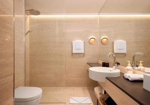 日内瓦Adina Apartment Hotel Geneva的一间带卫生间和水槽的浴室