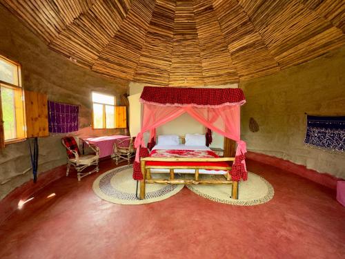 MakuyuniMaasai Eco Boma & Lodge - Experience Maasai Culture的一间卧室,卧室里配有一张带天蓬的床