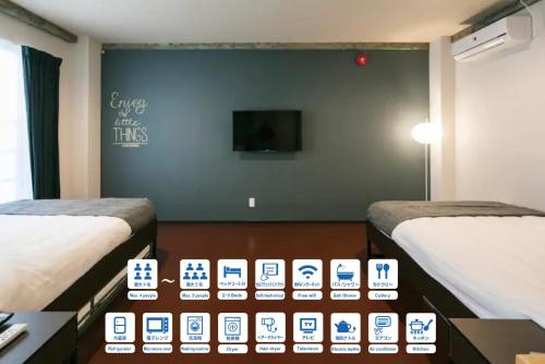 鹿儿岛ROI SPACE 鹿児島的客房设有两张床和一台墙上的电视