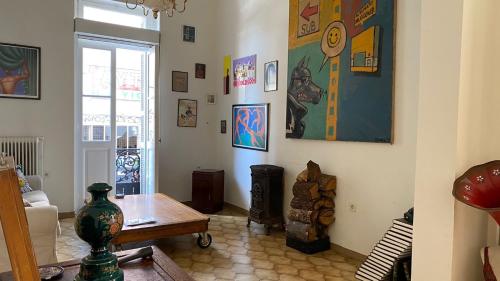 雅典Νεοκλασικό Αστικό Σπίτι χτισμένο το 1917.的客厅配有咖啡桌和墙上的绘画作品