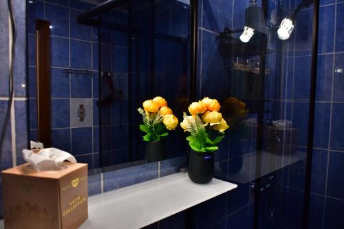 叶卡布皮尔斯Comfortable 4-Room Apartments in Jekabpils的蓝色瓷砖浴室,架子上放着两花瓶