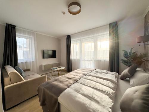 艾格扎洛克Salt Hill Premium Apartments的一间卧室配有一张床、一张沙发和窗户。