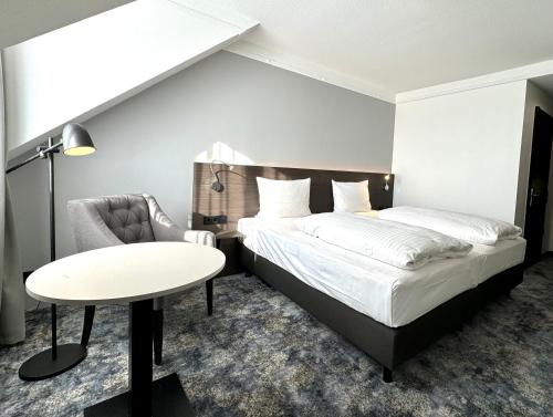 明登明登林佳特酒店 的卧室配有1张床、1张桌子和1把椅子