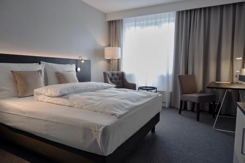 明登明登林佳特酒店 的酒店客房设有一张大床和一张书桌。