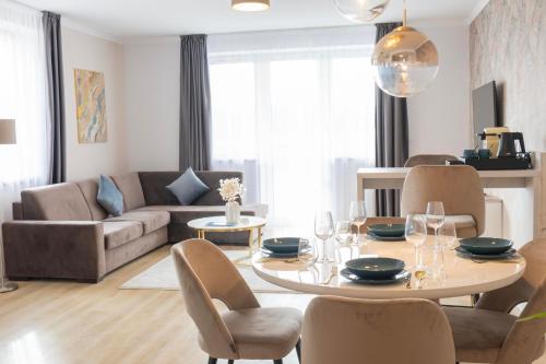 艾格扎洛克Salt Hill Premium Apartments的客厅配有桌椅和沙发