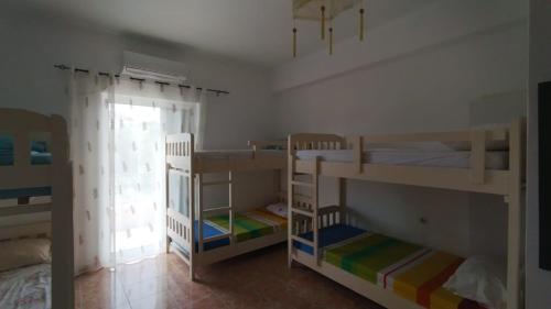 希马拉Oasis Hostel的客房设有三张双层床和一扇窗户。