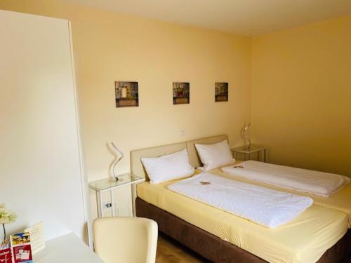 奥弗拉特Landhotel Bergischer Hof GmbH Marialinden的一间卧室配有一张带两个白色枕头的床