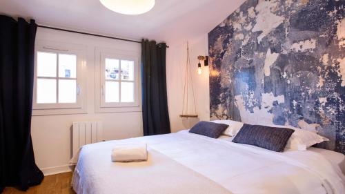蒙彼利埃Home Chic Home - Les Toits de Sainte-Ursule的一间卧室配有一张白色大床和黑色墙壁