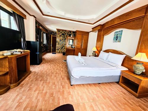 芭东海滩Rock Shore Patong的一间卧室配有一张大床和一台平面电视