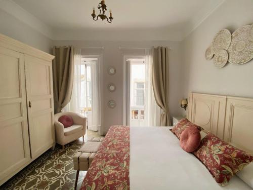 赫雷斯-德拉弗龙特拉La Gitanilla Alojamiento & Encanto Jerez的一间卧室配有一张大床和一把椅子