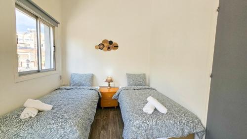 拉纳卡The Lemon Tree Hostel的带窗户的客房内设有两张单人床。