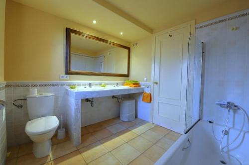 纳瓦拉Duplex Torremirona Resort的一间带卫生间、水槽和镜子的浴室