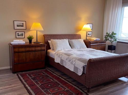 吕贝克The cozy family Retreat Lübeck的一间卧室配有一张带2个床头柜和2盏灯的床。
