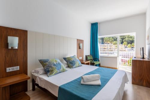 帕格拉海王星旅馆的一间卧室配有一张带蓝色毯子的大床