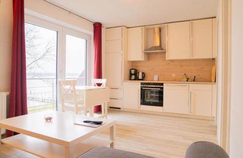 拉本基尔兴-福吕克Schleiblick App 18的厨房以及带桌子和窗户的用餐室。