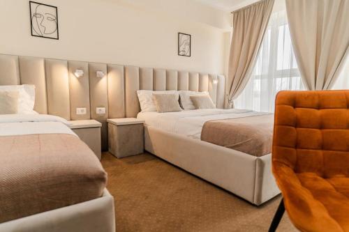 蒂米什瓦拉Pensiunea Elisei的酒店客房,配有两张床和椅子