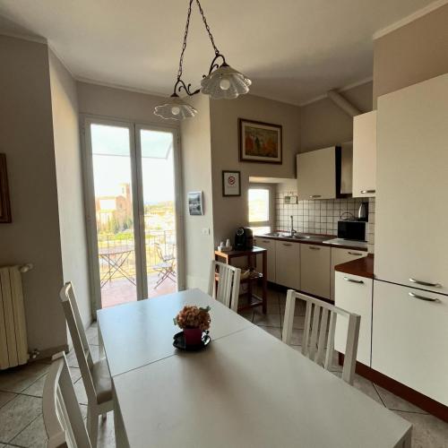 锡耶纳I Terzi Di Siena - Rooms Only的一间带白色桌椅的厨房和一间带桌子的厨房