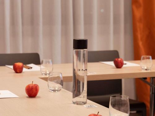 阿格拉泰布里亚恩扎Mercure Milano Agrate Brianza的桌子上装有玻璃杯的水瓶