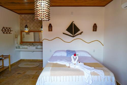 巴拉格兰德Casa do velejador的一间卧室配有一张带白色床单和吊灯的床。