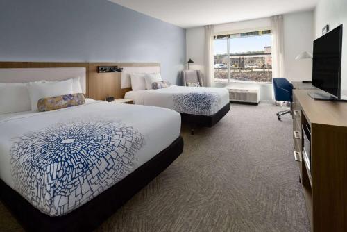 洛克斯特格罗夫La Quinta Inn & Suites by Wyndham Locust Grove的酒店客房设有两张床和一台平面电视。