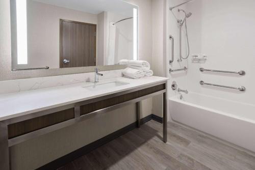 洛克斯特格罗夫La Quinta Inn & Suites by Wyndham Locust Grove的一间带水槽、浴缸和镜子的浴室