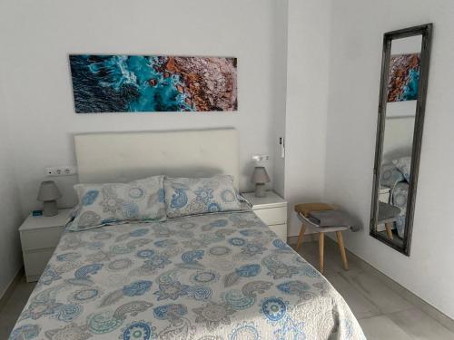 塔里法TURISMO LOS LANCES TARIFA( PARKING GRATUITO)的卧室配有一张床,墙上挂有绘画作品