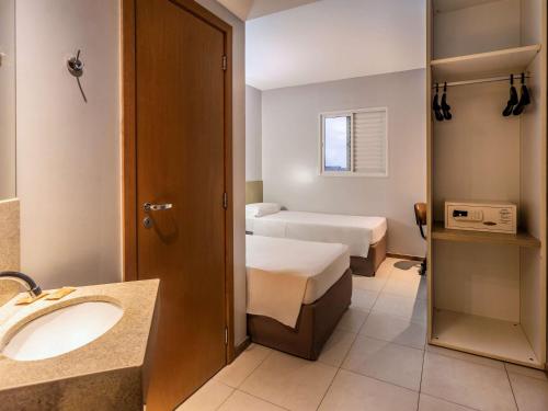 贝伦ibis Styles Belém do Pará的一间带水槽的浴室和一张位于客房内的床