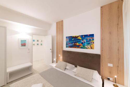莱切Lo Studio di viale Lo Re camere & caffe’的卧室配有一张床,墙上挂有绘画作品