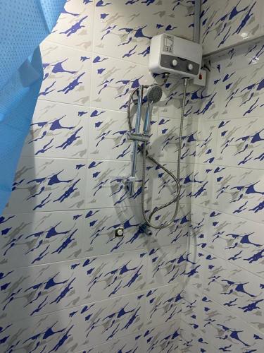 特马Kobbys Brands的浴室铺有蓝色和白色瓷砖,设有淋浴。