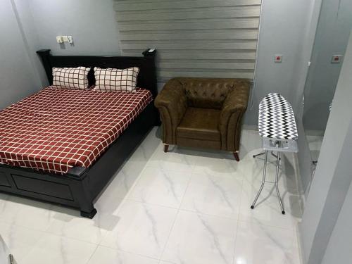 特马Kobbys Brands的一间卧室配有一张床和一把椅子