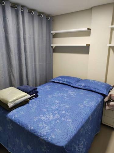 巴西利亚Apartamento encantador 1 Quarto na Candangolândia的一间卧室配有一张带蓝色棉被的床
