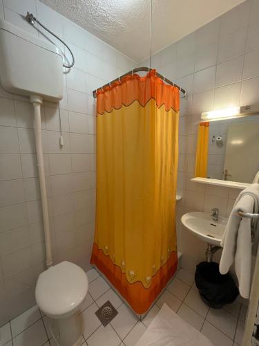 萨格勒布Hostel Arena的浴室设有卫生间和黄色的淋浴帘
