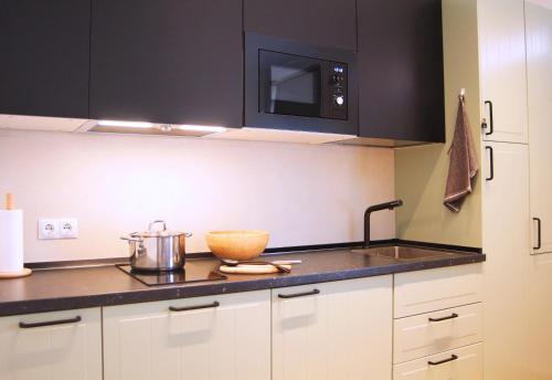 马德里Apartamento Marques de Zafra - Ventas的厨房配有黑色橱柜和柜台上的碗