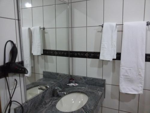巴西利亚艾拉姆巴西利亚酒店的浴室配有盥洗盆、镜子和毛巾