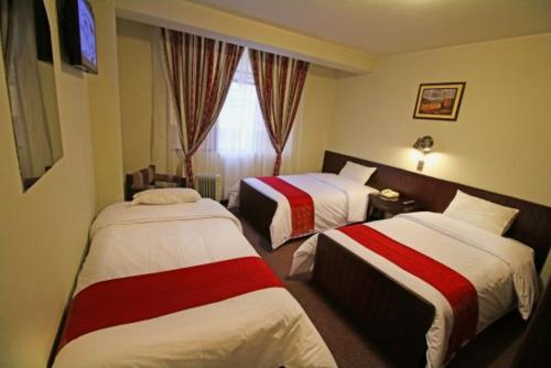 普诺Camino Real Puno的酒店客房设有两张床和窗户。
