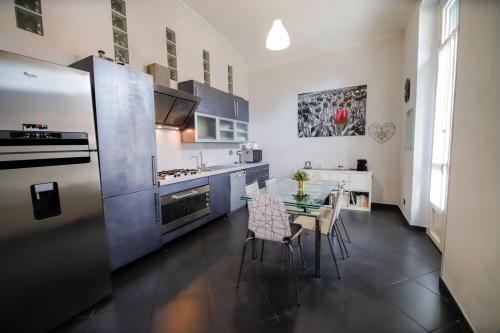都灵Appartamento Casa Nizza - Metro Lingotto fiere by Bib's Apartments的厨房配有桌椅和冰箱。