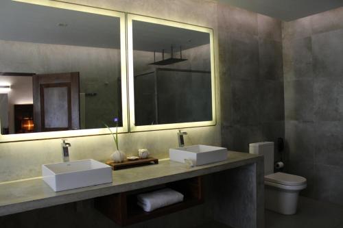 亭可马里Trinco Boutique Hotel的浴室设有2个水槽和镜子