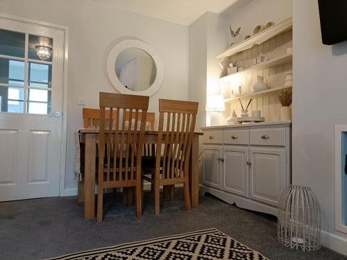 惠特彻奇Charming Terrace Home in Whitchurch的厨房配有桌椅和镜子