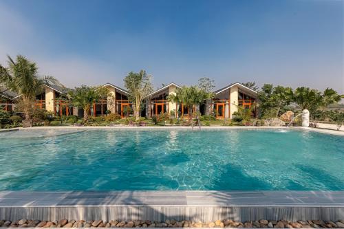 宁平La Vento Resort Ninh Bình的房屋前的大型游泳池