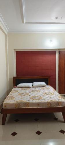 门格洛尔Prakruthi home 2的一间卧室配有一张大床和红色床头板