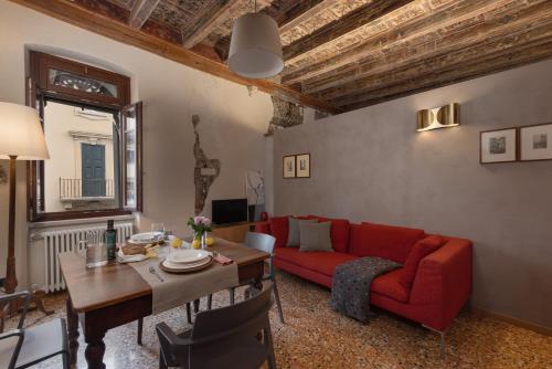 维罗纳罗佳玛姬儿公寓的客厅配有红色的沙发和桌子