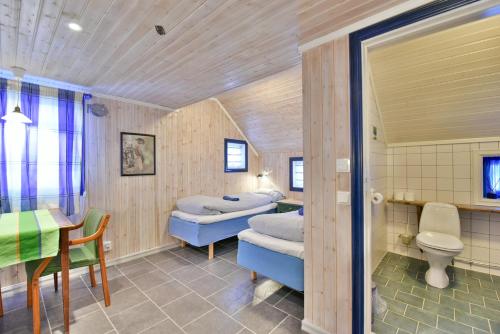 KongsfjordKongsfjord Arctic Lodge的客房设有两张床、一张桌子和一张桌子以及椅子。