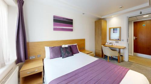 梅登黑德CIM Business Centre的配有一张床和一张书桌的酒店客房