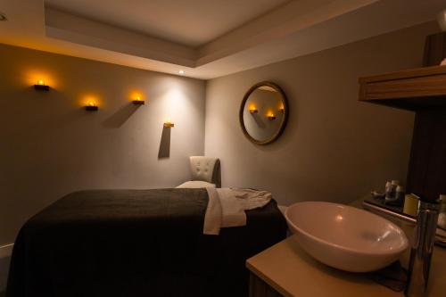 奇切斯特Harbour Hotel & Spa Chichester的一间带水槽、床和镜子的浴室