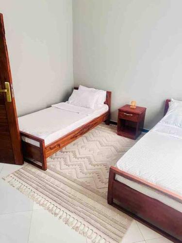 达累斯萨拉姆kaya homes的客房设有两张单人床和一张桌子。