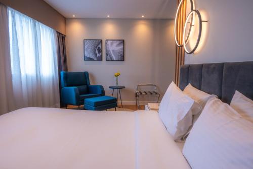 圣保罗eSuítes Congonhas by Atlantica的酒店客房,配有一张床和一张蓝色椅子