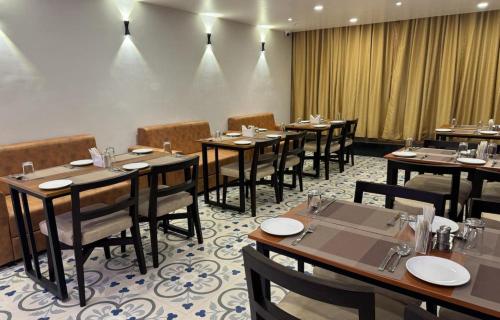 德奥加尔Hotel Taj Akash的一间在房间内配有桌椅的餐厅