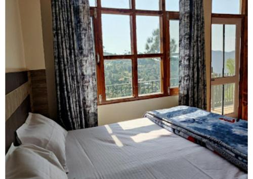 哈里瓦Hotel Gopi Dham Ashram Haridwar Near Vrindavan的一间卧室设有一张床和一个开放式窗户。